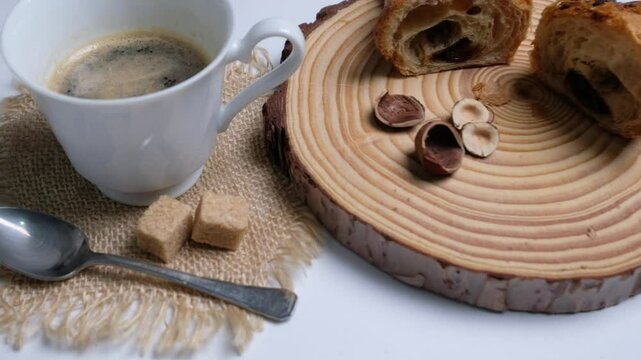 vista dall'alto di una tazza di caff&egrave; e brioche alle mandorle sul tagliere, movimento di camera 