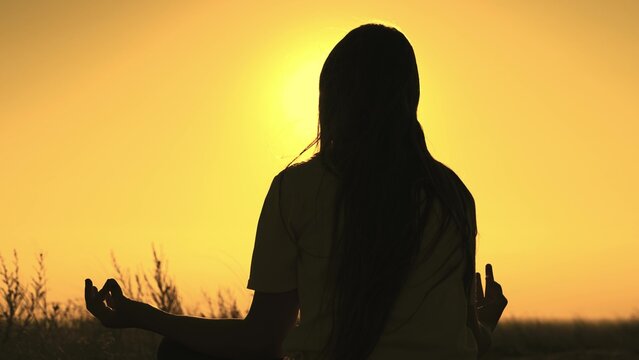 yoga hand sign. girl sunset doing yoga. female meditation glare sun. yoga stretching exercise. concentration outdoors concept. weight loss healthy lifestyle. fingers hand. hand gesture sunset. sport