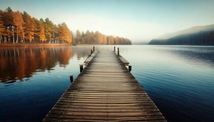 Fototapeta premium Muelle de madera solitario que se extiende hacia el lago brumoso durante el otoño, fotografía hiperrealista,