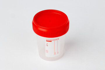 Sterile medical sample container with red lid on white background, Close-up of an empty sterile plastic medical sample container with a red screw cap
