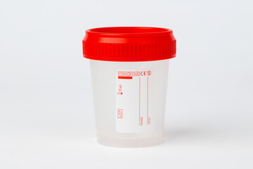 Sterile medical sample container with red lid on white background, Close-up of an empty sterile plastic medical sample container with a red screw cap
