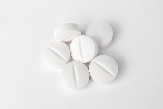 Stack of white paracetamol tablets on clean background, Close-up of several white paracetamol tablets stacked together, isolated on a plain white background, representing healthcare and medicine.
