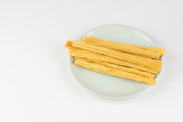 Raw dry Tofu skin or yuba in plate isolated on white background