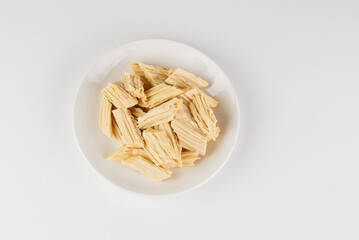 Tofu skin or yuba in a white plate top view isolated on white background