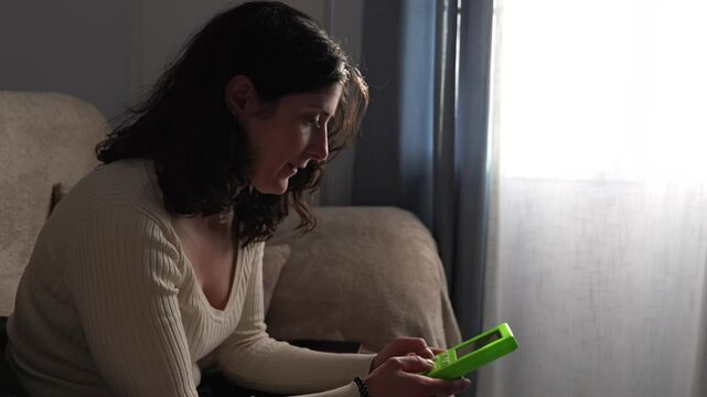 woman playing retro videogame at home sofa