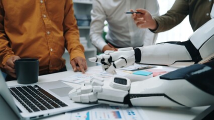 A sophisticated robot arm assists a diverse group of professionals during a collaborative meeting, enhancing communication and productivity in an innovative office setting.Noogenesis