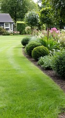 Obraz premium Serene garden path leads through vibrant plants and well-trimmed shrubs, showcasing a beautiful residential landscape during daylight.