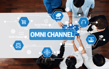 A diverse group of professionals collaborates around a table, discussing omni channel marketing strategies with digital technology and customer engagement methods. Amity