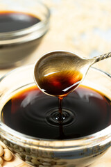 Soy sauce poured from a spoon into a saucepan close-up