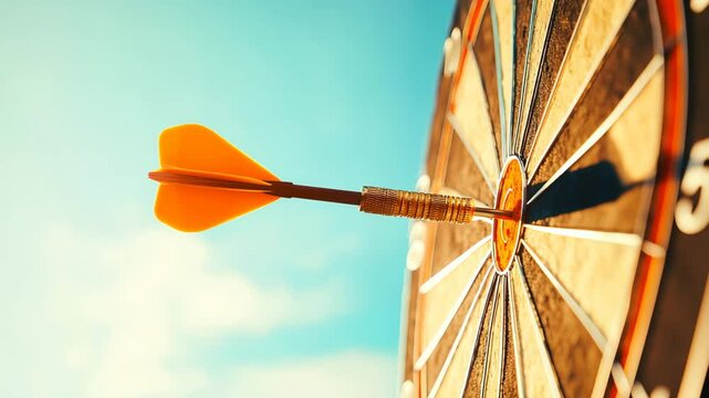 Close-up of a dart hitting the bullseye on a colorful dartboard against a blue sky.