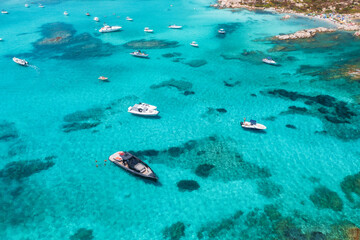 Aerial view of beautiful luxury yacht and boat in blue sea in summer. Sardinia, Italy. Top drone view of speed boat, sea coast, transparent azure water. Travel. Tropical landscape. Yachting. Seascape