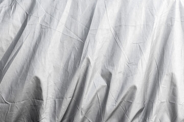 Abstract silhouette shadows behind wrinkled gray fabric texture