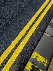 Fototapeta premium A yellow line is painted on a black road