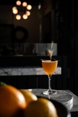 Cocktail in Dimly Lit Bar with Citrus in Foreground