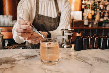 Bartender Using Tweezers for Cocktail Garnish