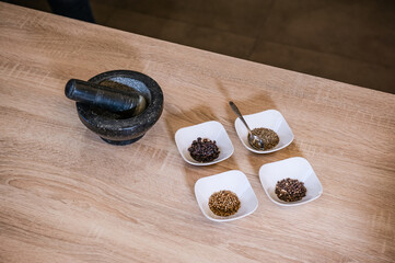 A kitchen marble mortar and spices arranged in bowls during cooking pilaf. Cook recipe step-by-step. Pilaf recipe in pictures.