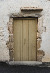 Destroyed white wall of abandoned building with wooden door