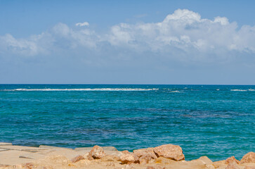 Clear Blue Ocean Waves and Rocky Shoreline under Bright Sunny Sky
