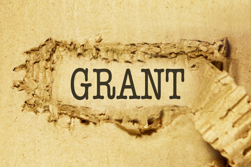 The words about grant funding are written on torn corrugated cardboard, on a white background....