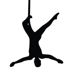 Silhouette of a graceful aerial acrobat performing a complex pose on silks