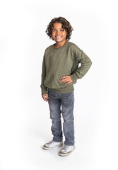 A casual studio portrait of a cute, smiling, diverse bi-racial boy standing. Isolated on a white background. Real person concept photo