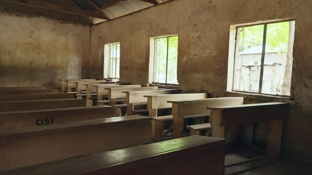 Empty school classroom in African country in small village or town during break. Vacations or school holiday in low income community. Local gathering room or church with wooden benches and adobe walls