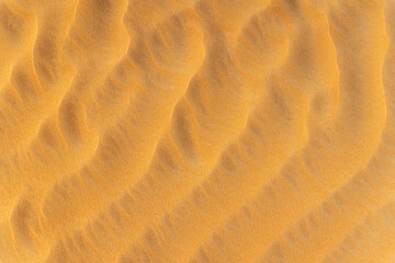 Sand summer smooth texture. Close up of sand wavy dune background. Copy space for text. Top view.