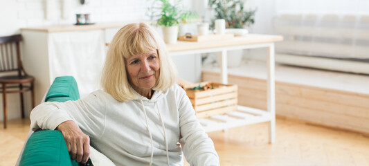Banner an elderly woman lost in peaceful thoughts in her cozy home. Contemplation, solitude, life...