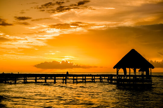 Silhouette of hut and wooden jetty at sunrise,  Akumal, Tulum, Mexico