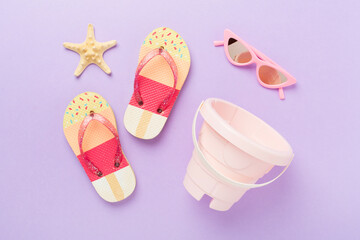 Children's flip flops and beach toys on color background,,top view