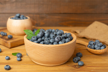 Bowl with fresh blueberries on wooden table