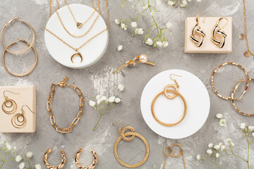Elegant golden jewelry with decoration on concrete background, top view