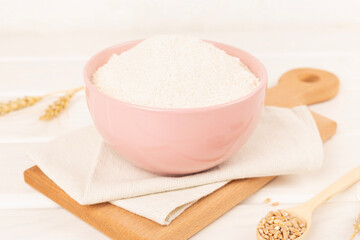 Bowl with spelt flour on wooden table