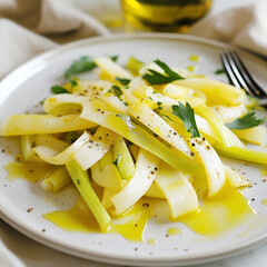 A plate of vibrant leek salad styled beautifully with olive oil and pepper