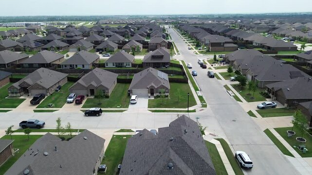 New construction two story houses solar roofing along large residential street, Myrick Lane in Princeton suburbs Dallas, upscale suburban homes in fast growing Collin County, North Texas, flyover