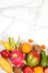 Dragon fruit, pitaya, mango, kiwi, avacado, apples, citrus and dried apricots on a sunny table with space for text. Healthy vegan food for weight loss. Banner with tropical exotic fruits and juice