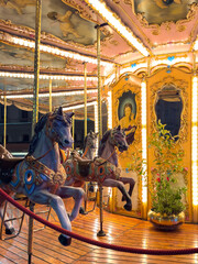 vintage carousel horses illuminated at night in Florence, Italy. ornate decorations and warm festive lights. nostalgic charm of traditional amusement © Ruslana