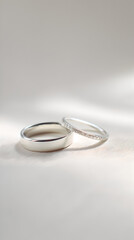 Close-up of elegant wedding rings showcasing intricate designs on a soft, neutral fabric background