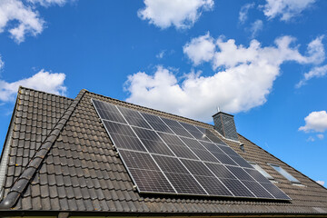Photovoltaic panels producing renewable energy on rooftop under cloudy sky