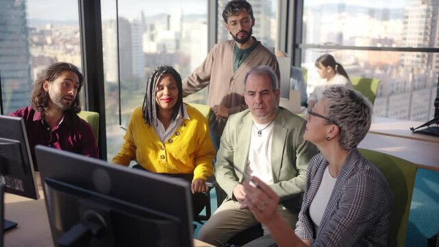 Diverse professional team analyzing complex business data while collaborating near computer, city skyline visible through expansive office window during strategic meeting