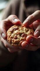 person holding a cookie in their hands