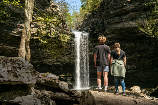 Rear view of Two adults looking at a scenic waterfall in the Ozark Mountains after a beautiful nature hike. 