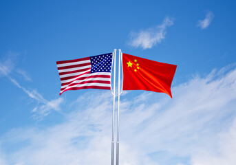 flags of China and USA flags over blue sky background.