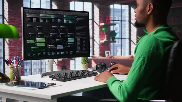African american software developer does visual coding and creating software, implementing algorithms. IT expert at home working with notes tree and code language, app performance. Camera B.