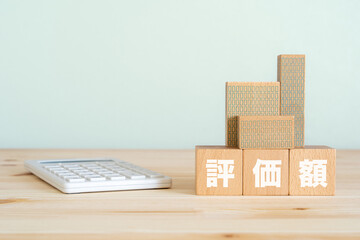 評価額と書かれたブロック、不動産の模型、電卓