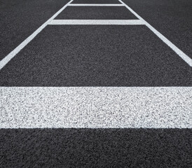 Fototapeta premium Textured black track or road surface with thick horizontal lines. Artificial rubber black surface of a running track or road.
