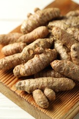 Raw tumeric rhizomes on white table, closeup