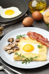 Delicious crepe bretonne with bacon, mushrooms and arugula served on grey table, closeup
