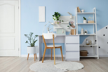 Interior of stylish office with workplace, pegboard and plants