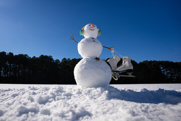 Snowman on snow winter background. Winter holiday scene. Snowman with scarf and hat. Happy snowman...